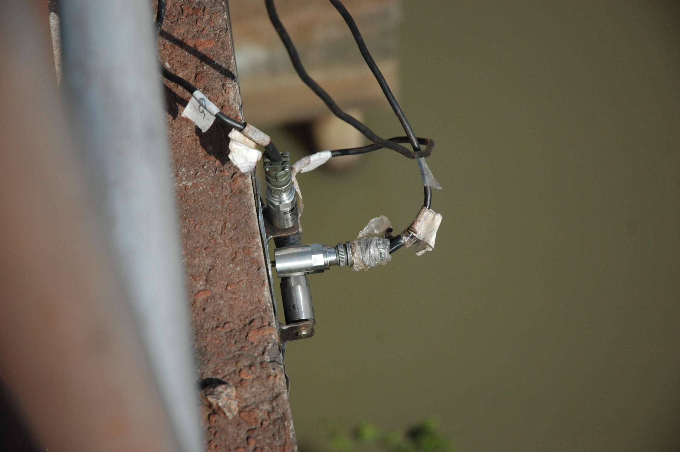 Acelerômetros piezoelétricos em arranjo triaxial instalados em uma ponte ferroviária.